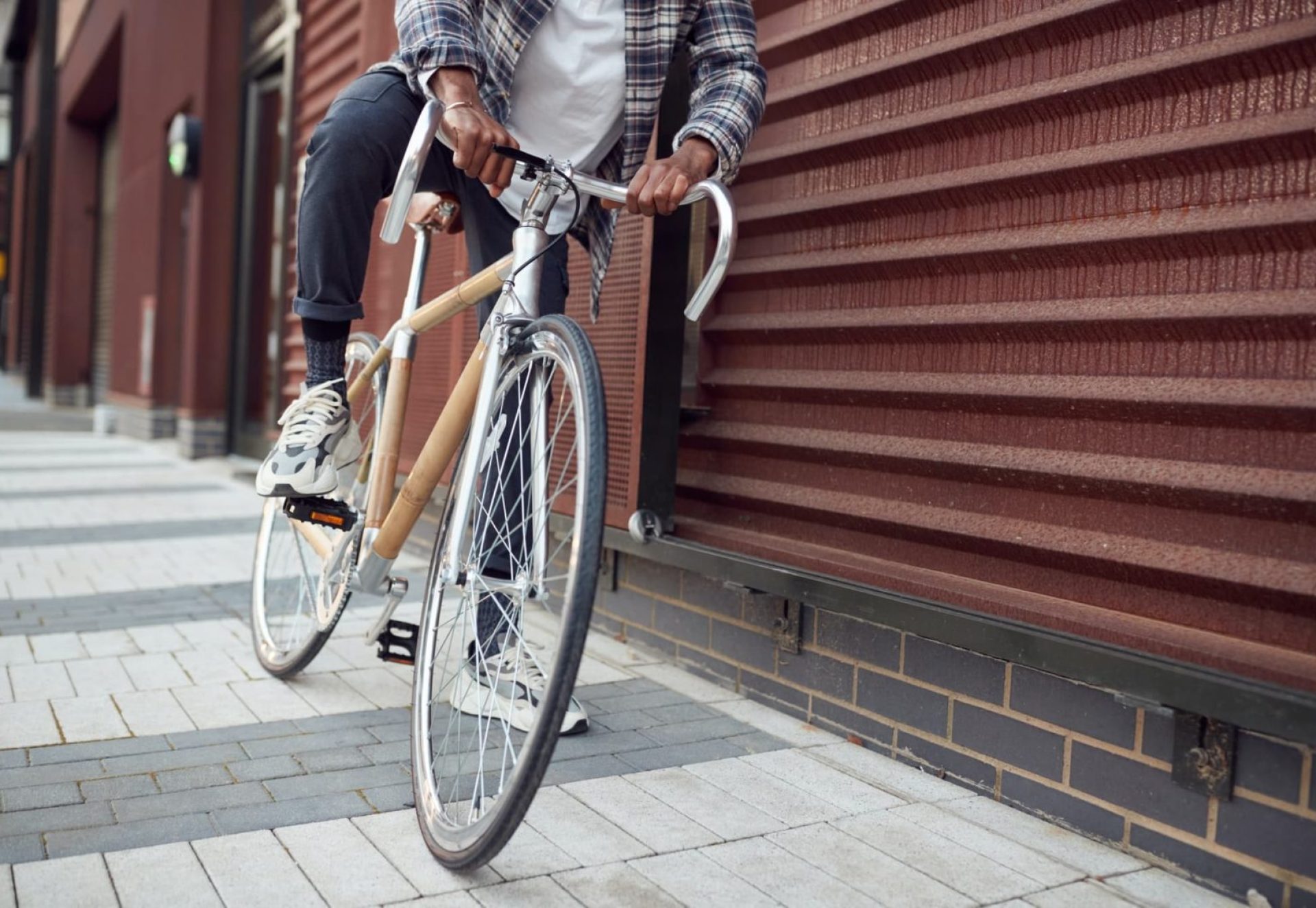 Close Up Of Man Riding Sustainable Bamboo Bicycle On City Street Close Up Of Man Riding Sustainable Bamboo Bicycle On City Street