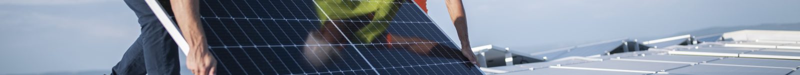 Team of two engineers installing solar panels on roof.